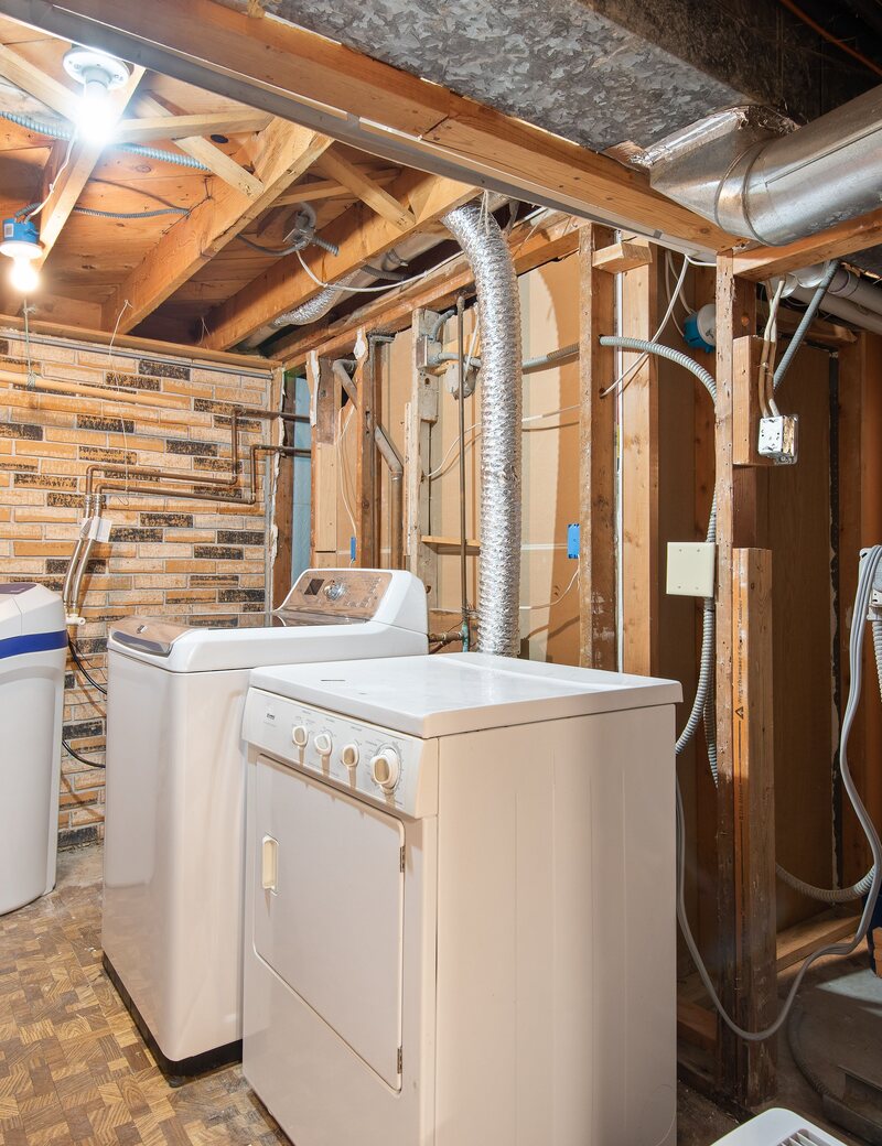 Residential laundry room with exposed dryer vent ducting
